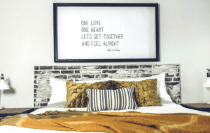 an oversized wall print above the bed with song lyrics