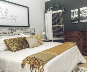 Boho master bedroom with white bedding and white curtains