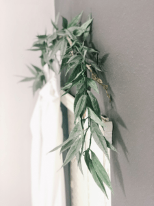 dreamy bedroom curtains hung on tree branch with greenery