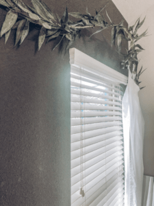 greenery draped on a tree branch curtain rod