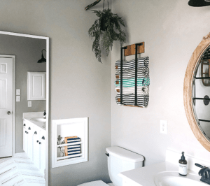 towel storage for small bathroom showcased on the wall with towels rolled and stacked in it.