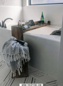 bathtub with a bathtub tray that has a tablet holder, bathsalts, soaps