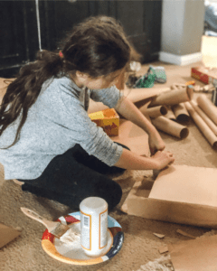daughter helping modge podge board game boxes