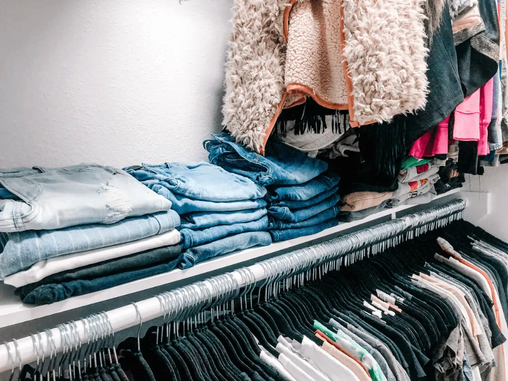 easy diy closet shelf holding jeans and hoodies