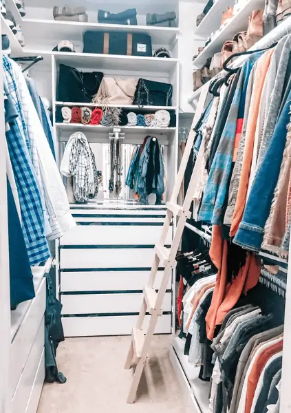 A beautifully organized walk in closet with a scarf hanger