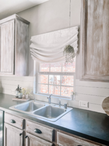 Drop Cloth Roman Shade Hung High On Wall Above Kitchen Sink