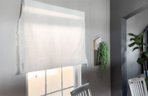 Drop cloth hung from window blinds before pinching up the sides